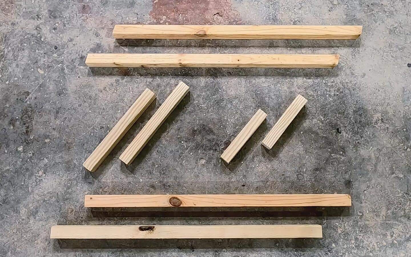 Assorted pieces of wood for a desk lying on the ground.