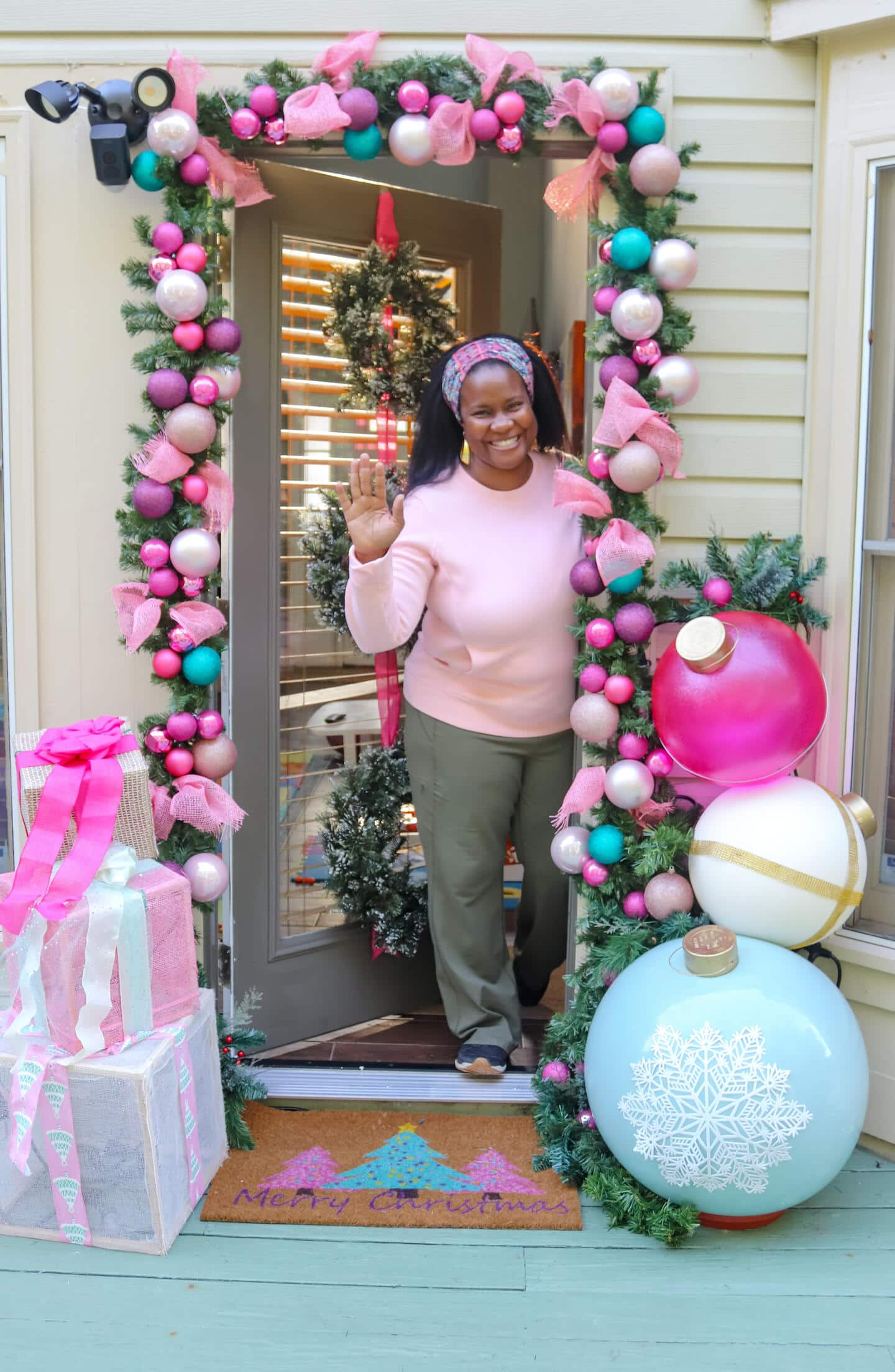 A person standing under the decorated patio entry.