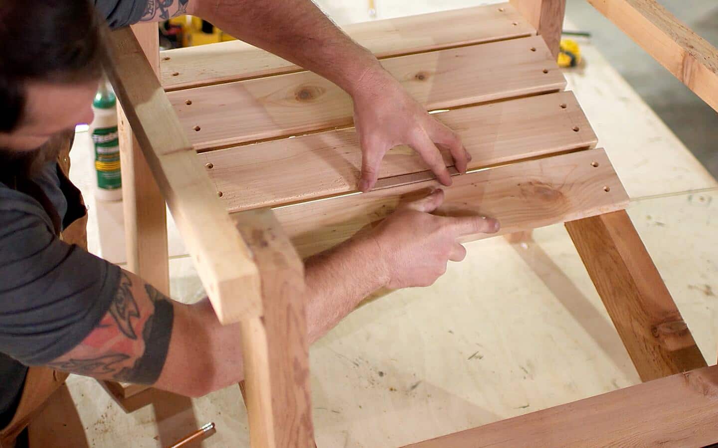 A person attaching the seat slats of an Adirondack chair. A person attaching the seat slats of an Adirondack chair.