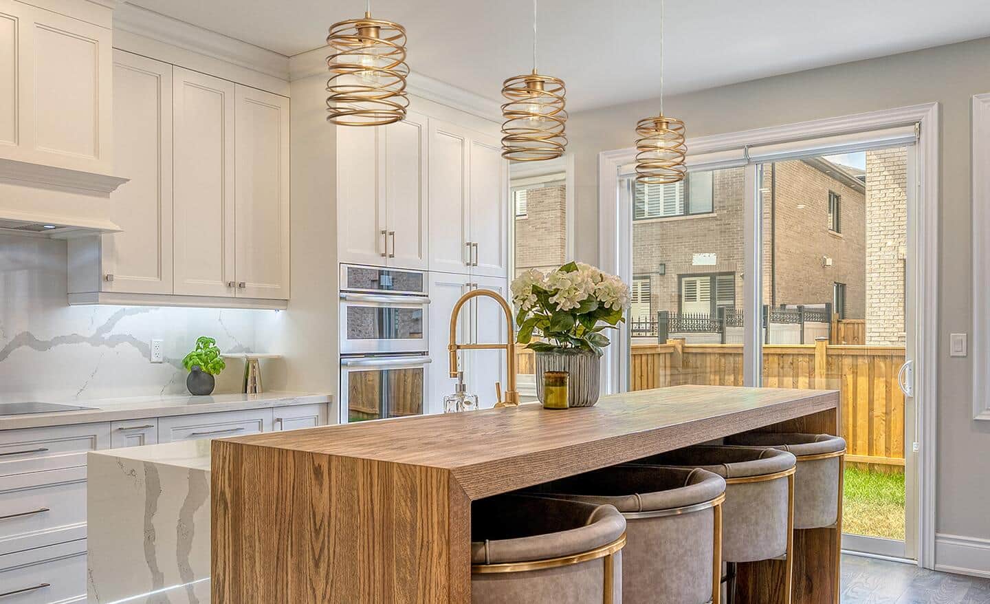 A kitchen island lit by three modern pendant lights.