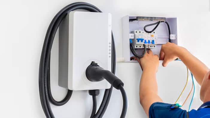 An EV charger hangs on a garage wall.