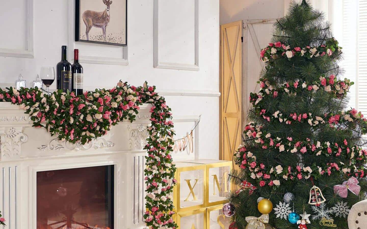 A Christmas tree decorated with red and green ornaments with wrapped gifts at its base in a living room.