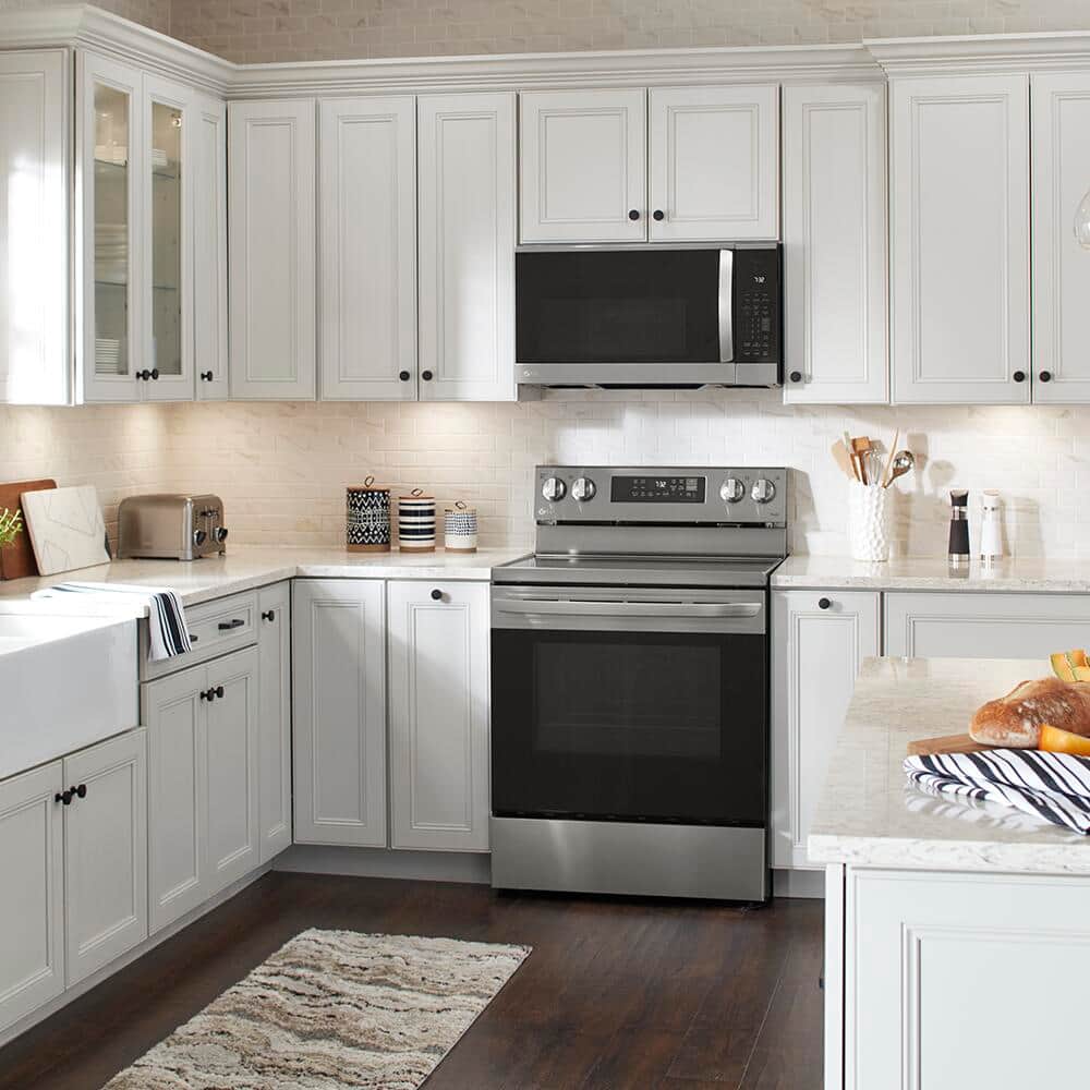 A white kitchen featuring a range and microwave.