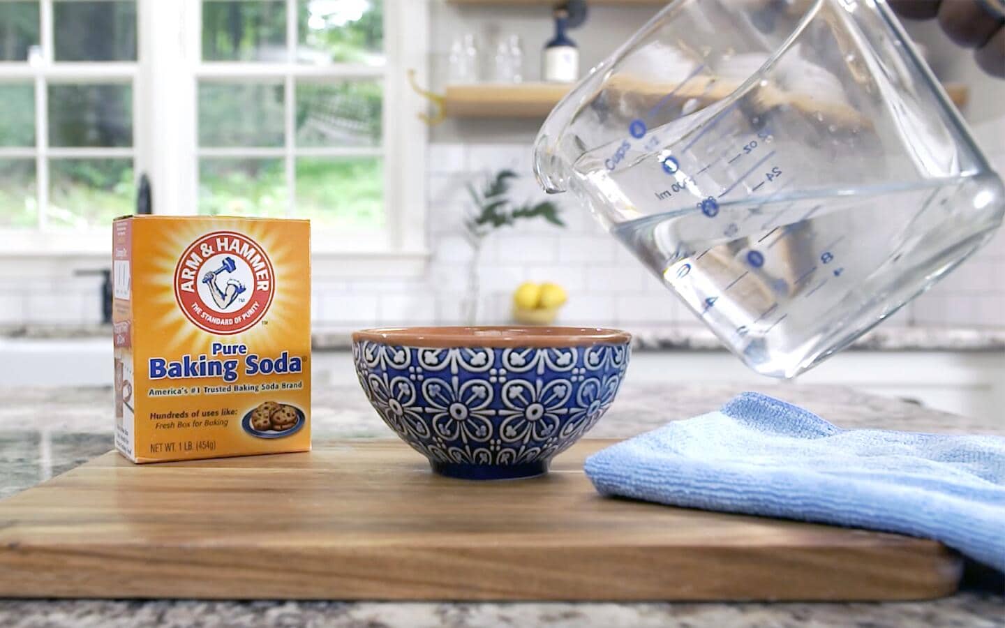 Someone mixing baking soda and water in a bowl to repair scratched glass.