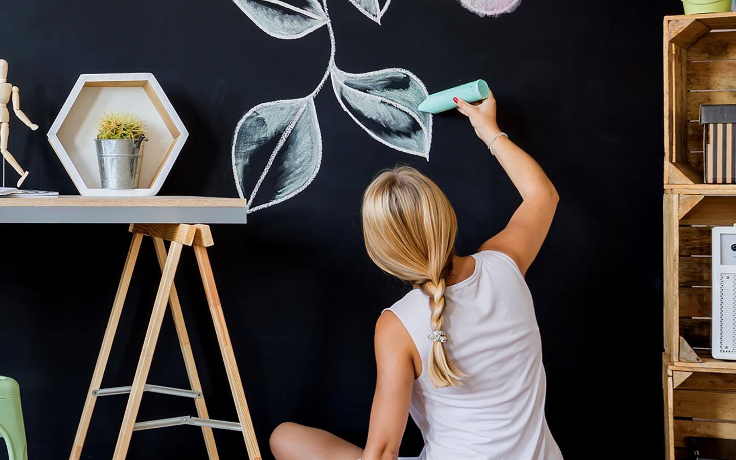 Someone drawing a pattern on a chalkboard wall. Someone drawing a pattern on a chalkboard wall.