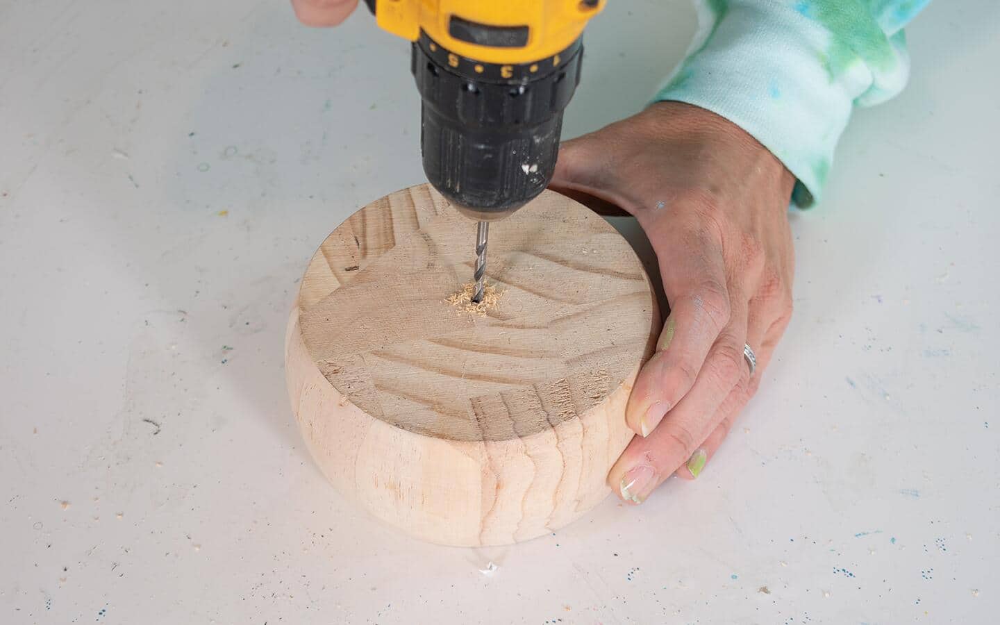 Someone drilling a hole in a wood base. Someone drilling a hole in a wood base.