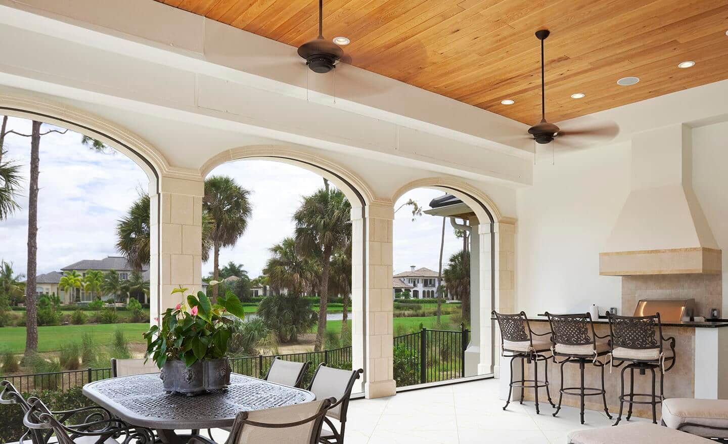 A ceiling fan on a patio with high ceilings.