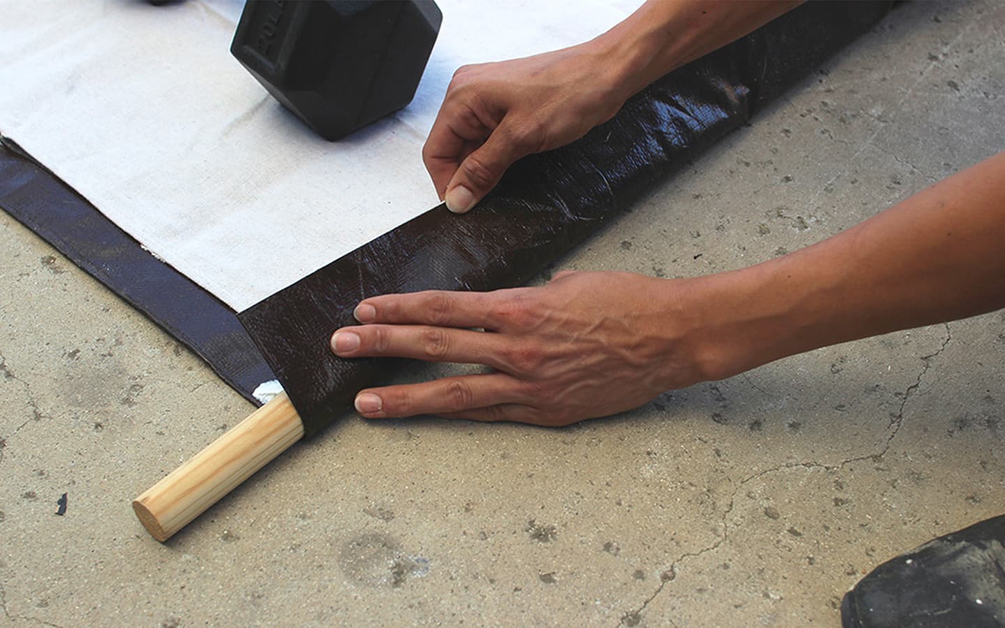 The dowel rod is folded into the edge of the tarp.