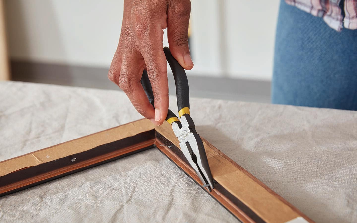 A person uses steel nose pliers to remove staples. A person uses steel nose pliers to remove staples.