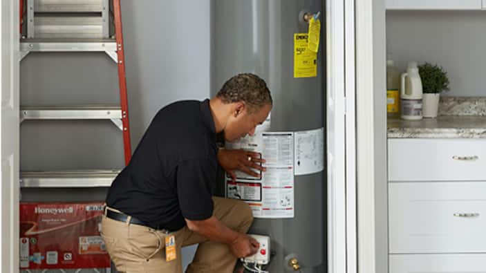 A Pro inspects a water heater.