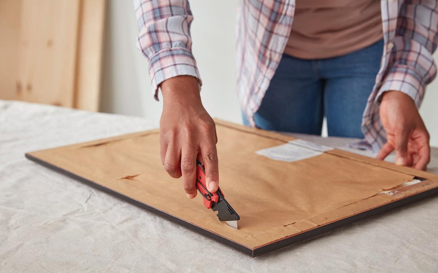 A person removes the paper backing from a frame. A person removes the paper backing from a frame.