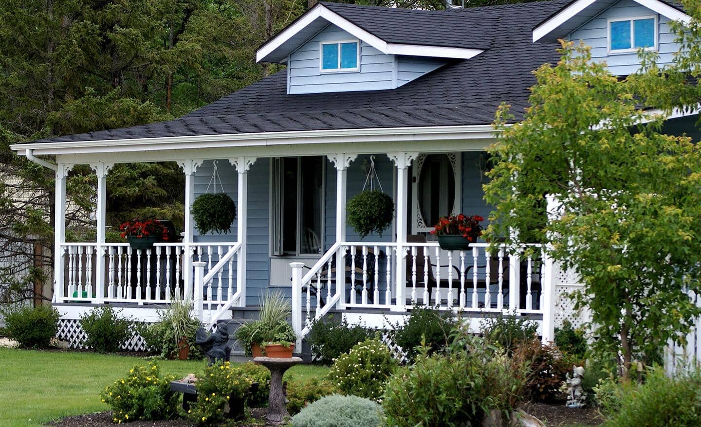 A white picket fence surrounds the front yard of a cottage.