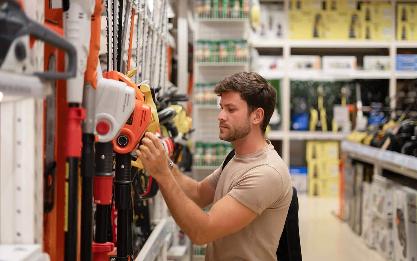 Someone looking at several different hedge trimmers. Someone looking at several different hedge trimmers.