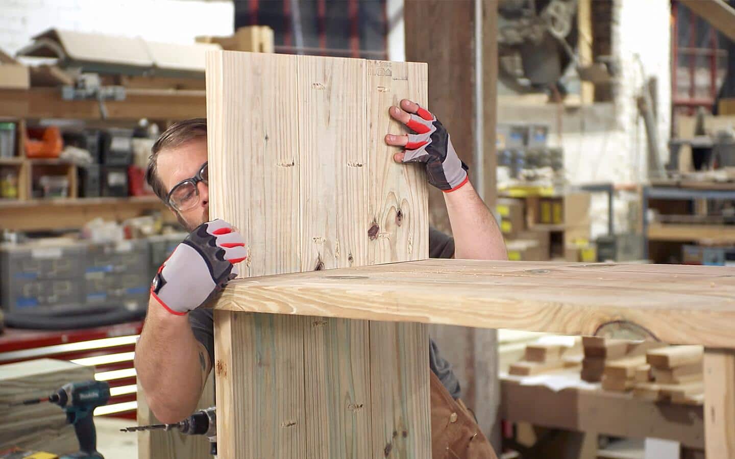 Someone adds the top panel of an outdoor wood grill station.