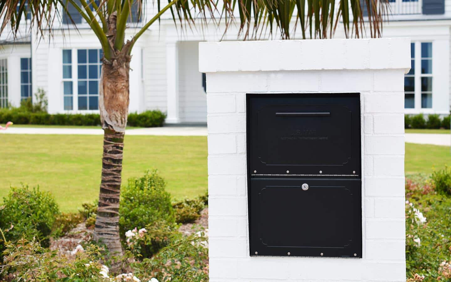A locking mailbox installed in a white brick wall. A locking mailbox installed in a white brick wall.
