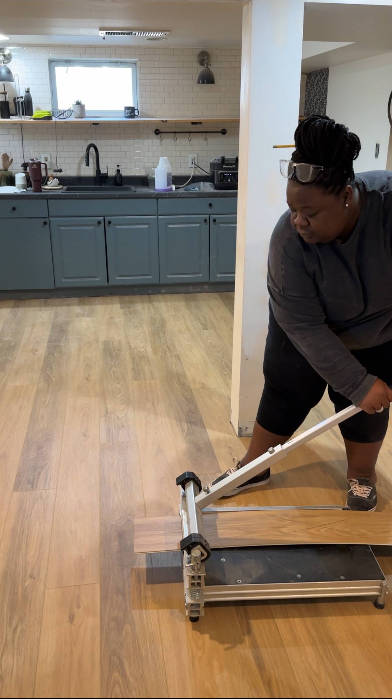 A woman cutting a laminate plank using a Laminate Floor Cutter.