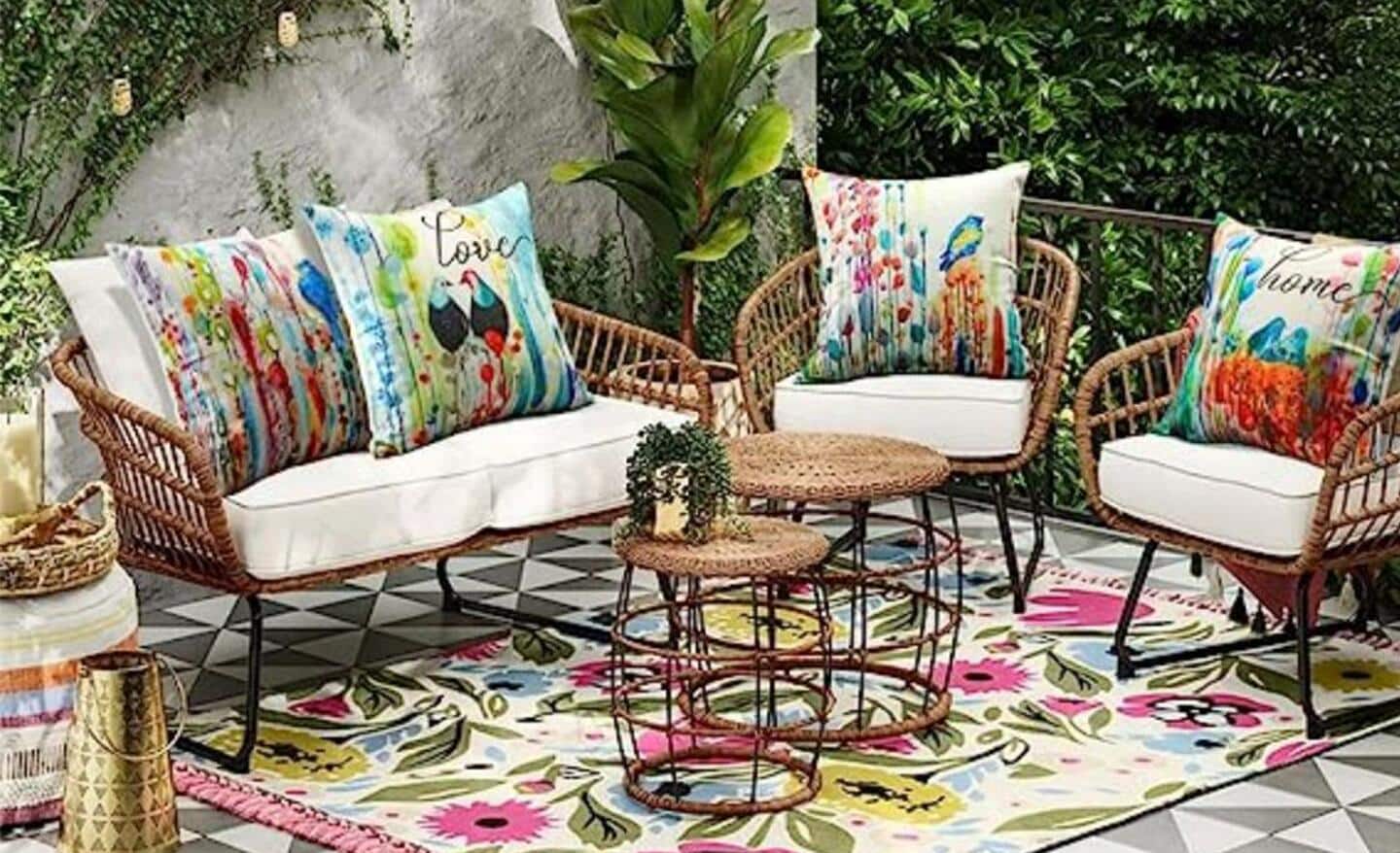 Colorful decorative pillows and other patio accessories on a decorative rug.