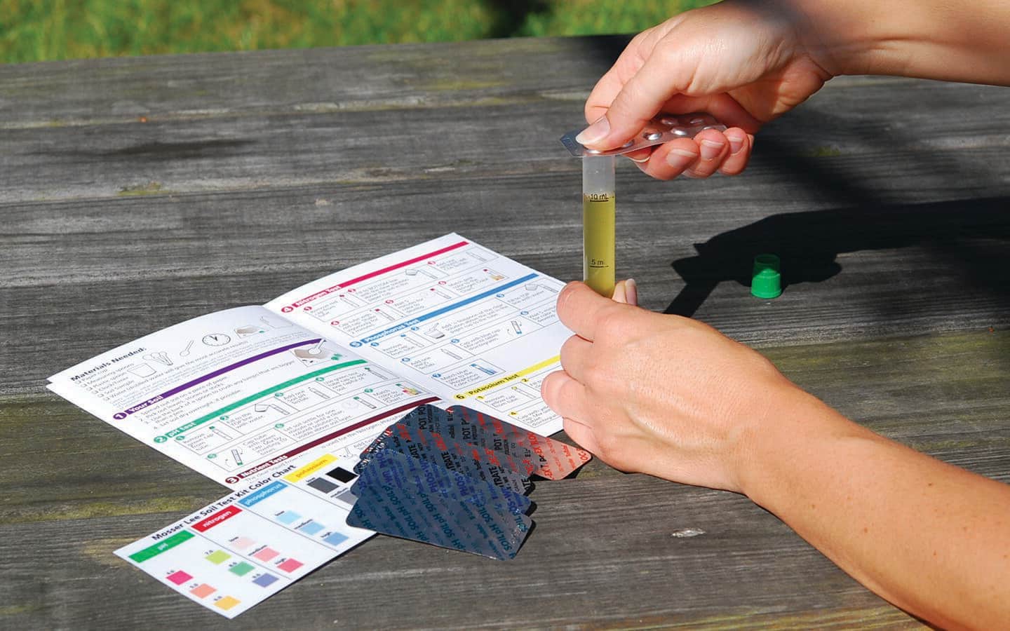 Person testing soil with a home soil test kit