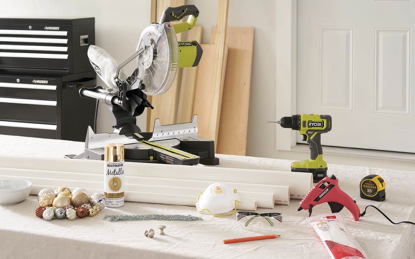 A circular saw, cordless drill, PVC pipe and other materials gathered in a workshop. A circular saw, cordless drill, PVC pipe and other materials gathered in a workshop.