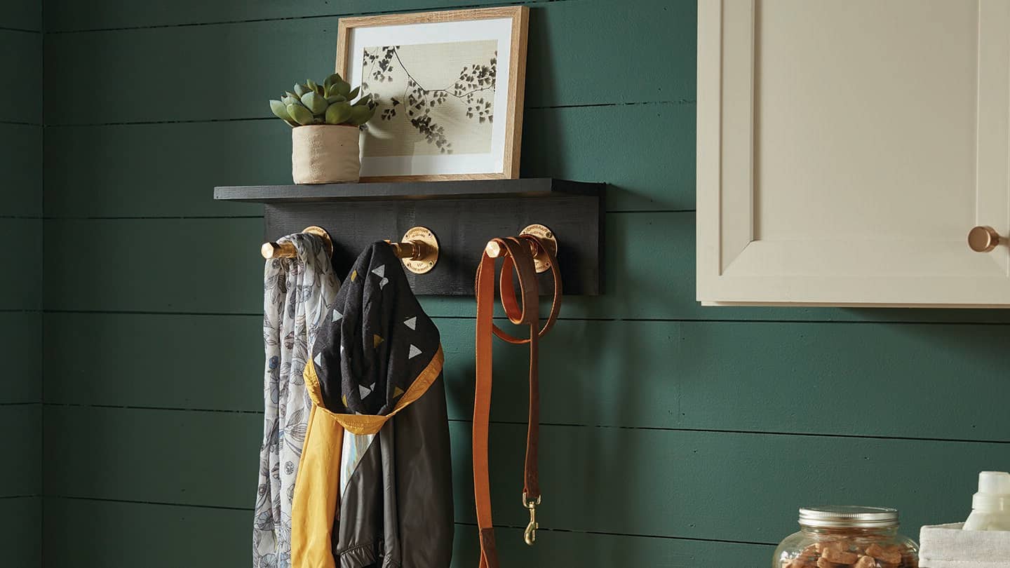 A DIY coat hanger made with wood and pipe.