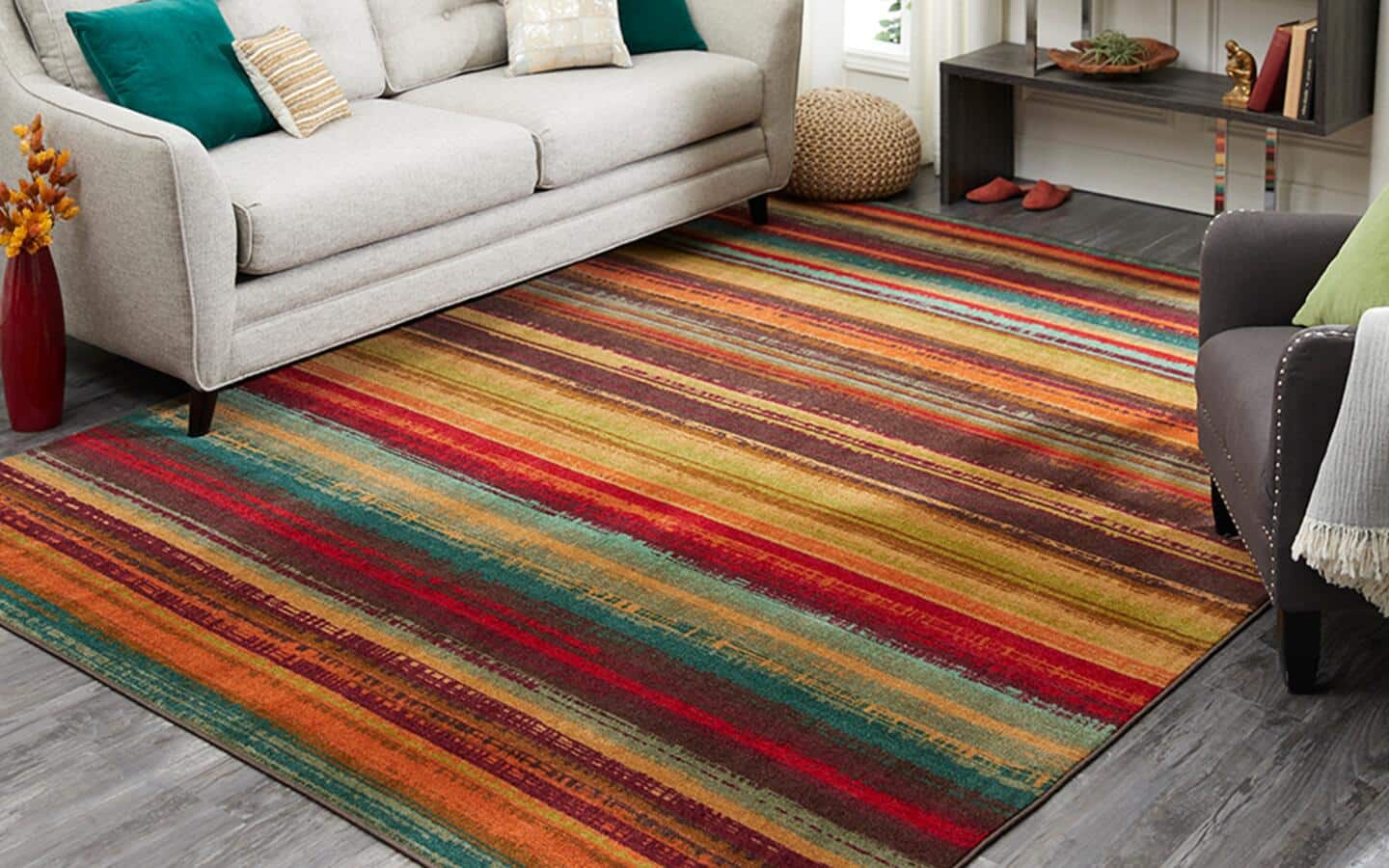 A striped rug lays in front of white couch in a living room.
