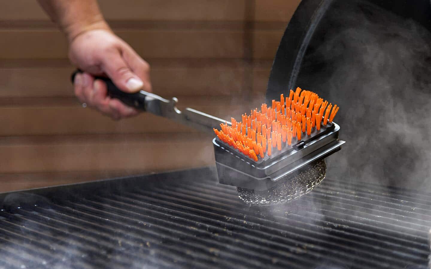 Someone cleaning a charcoal grill. Someone cleaning a charcoal grill.