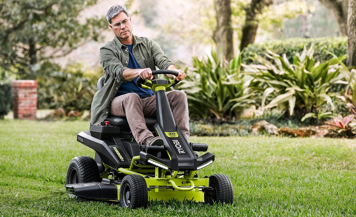A person riding a rear engine riding mower. 