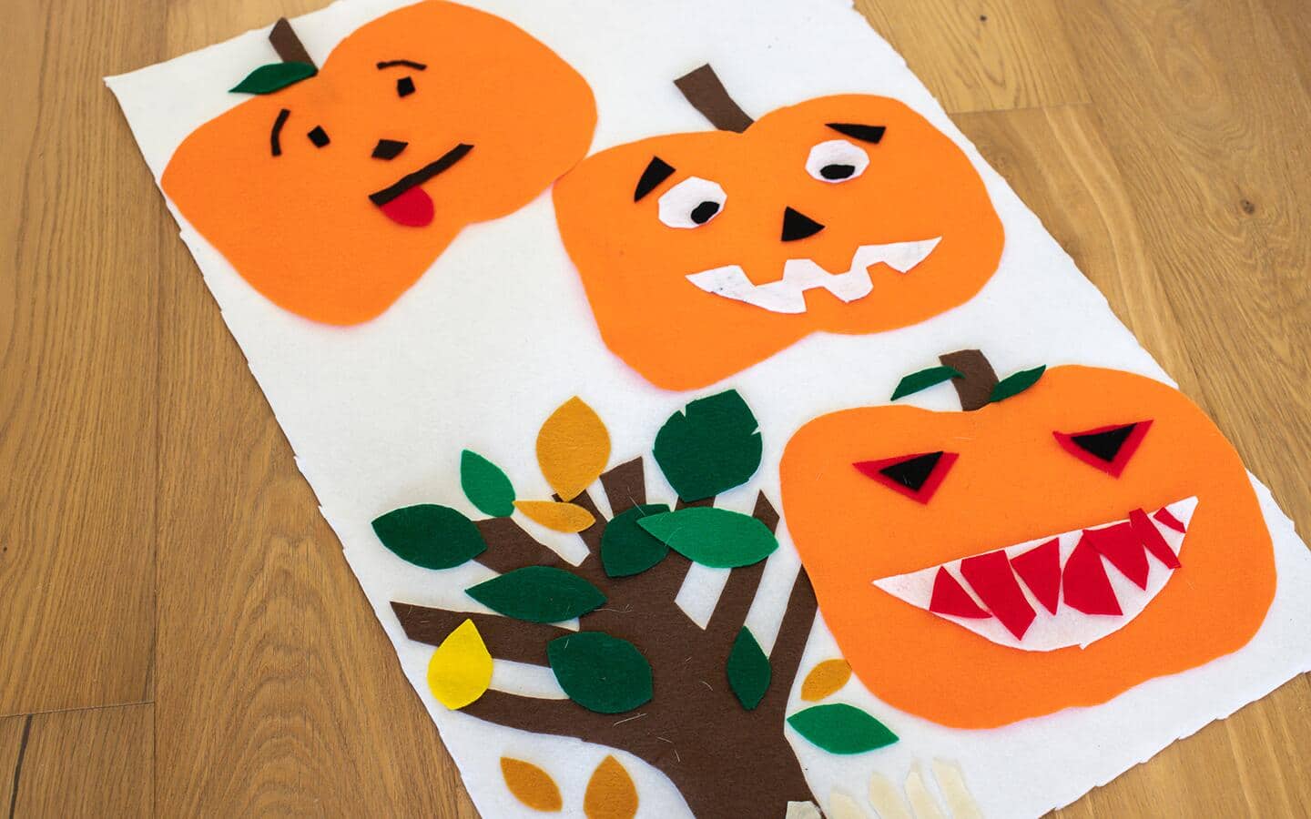 Felt pumpkin artwork lying on a table.