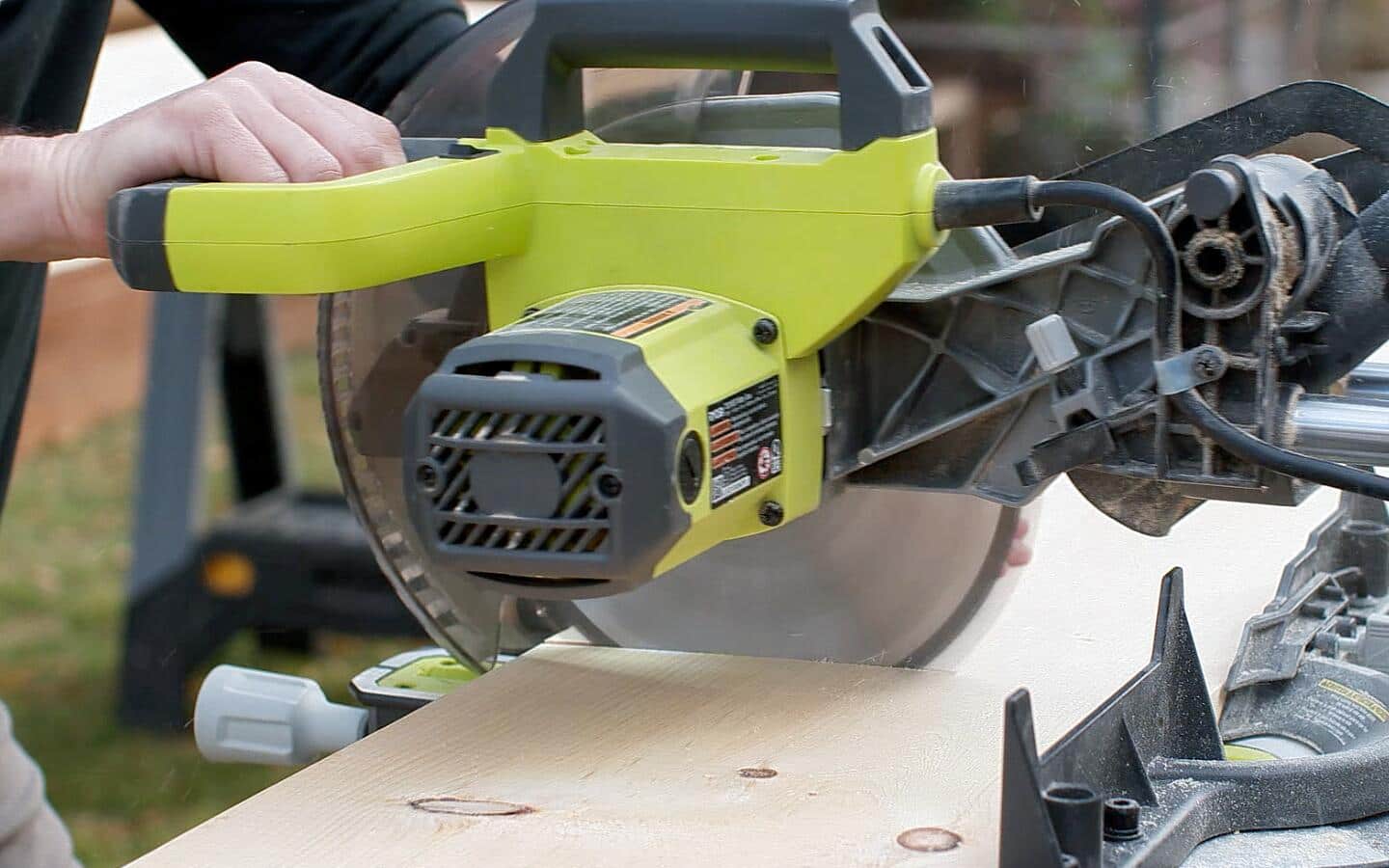 A person using a circular saw to cut a shelf for the closet organizer.