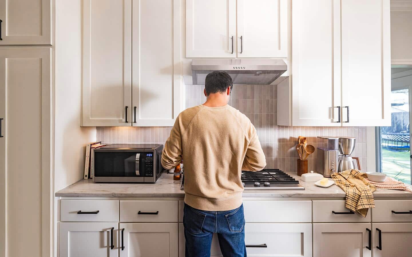 Installed motion sensor lighting turned on as a man uses a smart range. Installed motion sensor lighting turned on as a man uses a smart range.