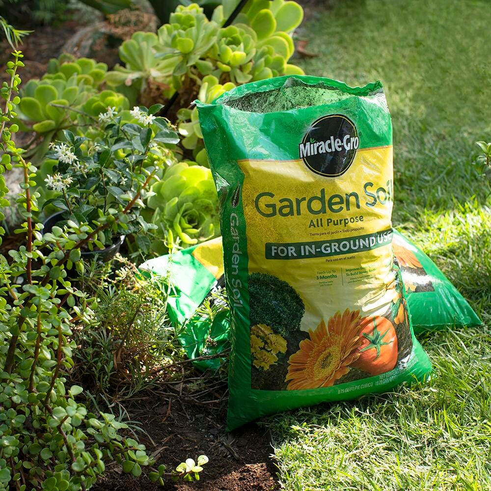 Two bags of garden soil on the grass in a garden