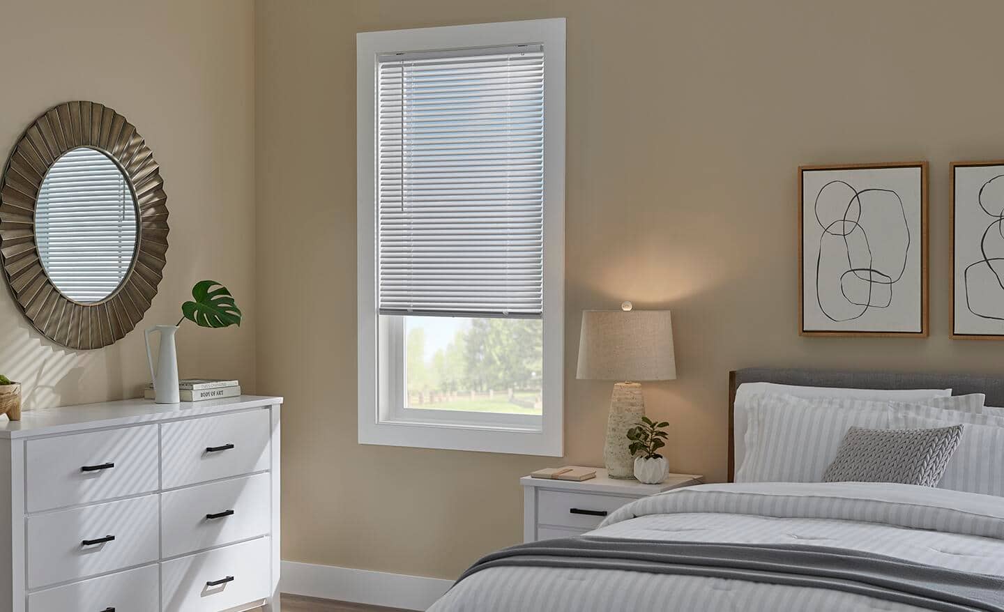 Aluminum blinds in white cover a bedroom window.