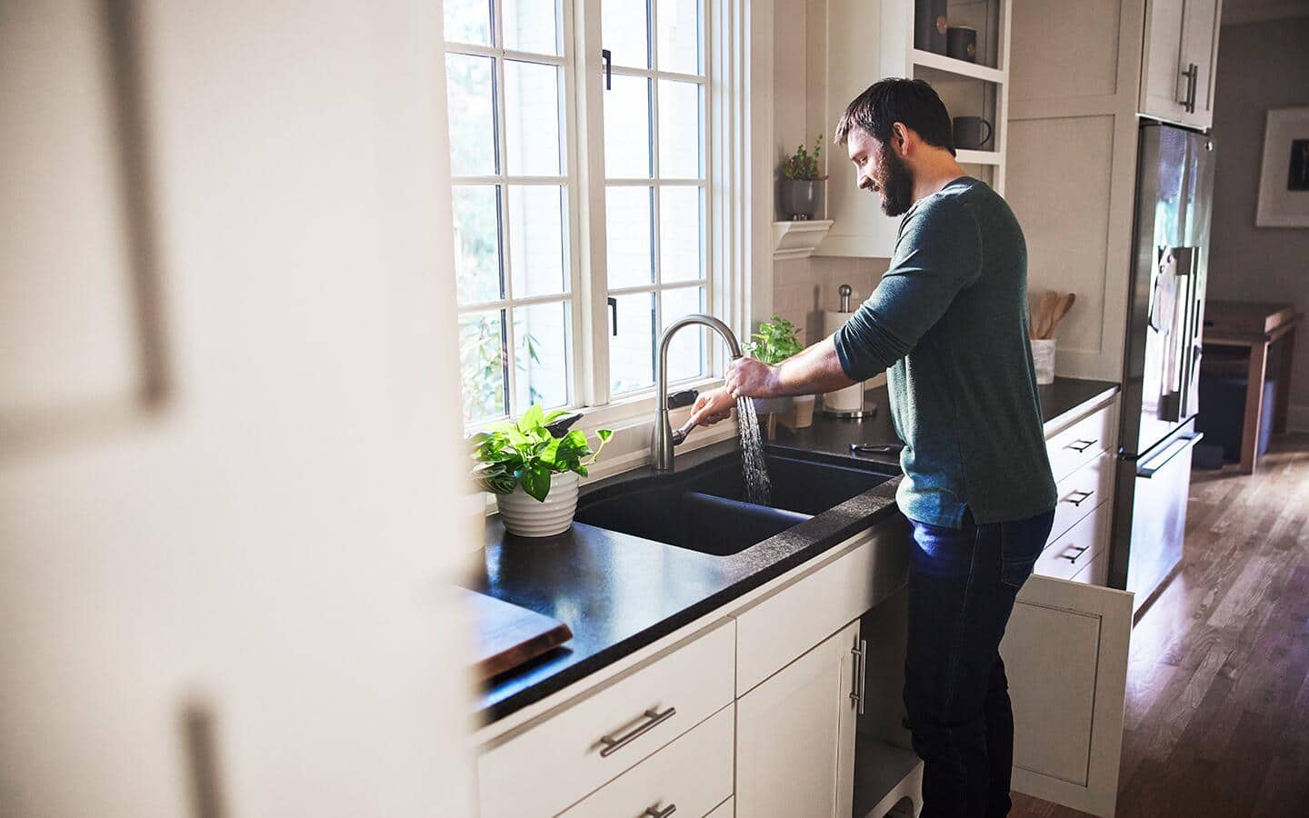 Someone washing dishes in a home kitchen with a newly installed sink.  Someone washing dishes in a home kitchen with a newly installed sink.