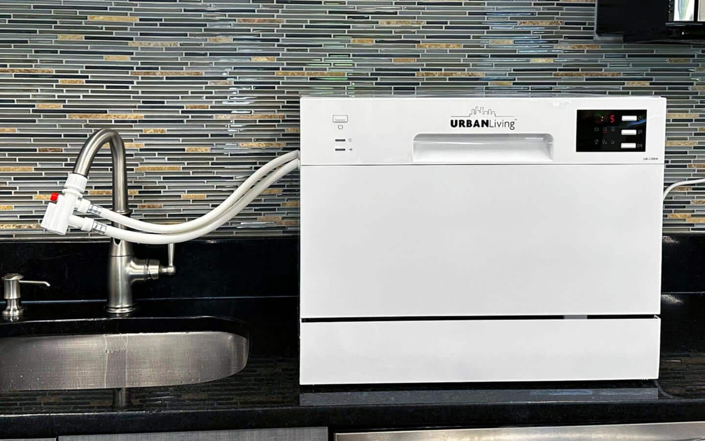 A portable dishwasher hooked up to a kitchen sink A portable dishwasher hooked up to a kitchen sink