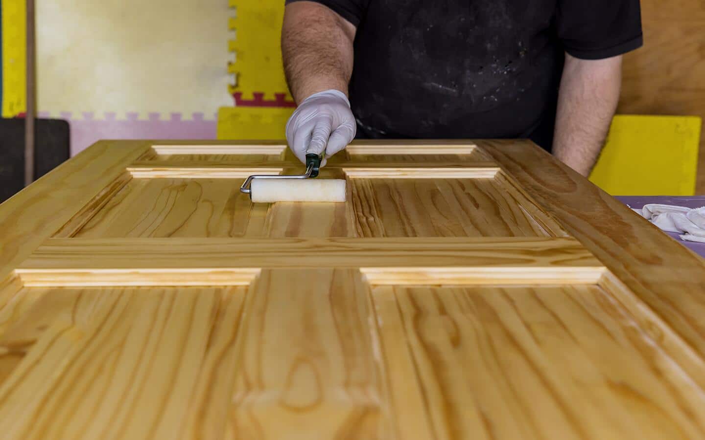 A person applies a coat of stain to a barn door. A person applies a coat of stain to a barn door.