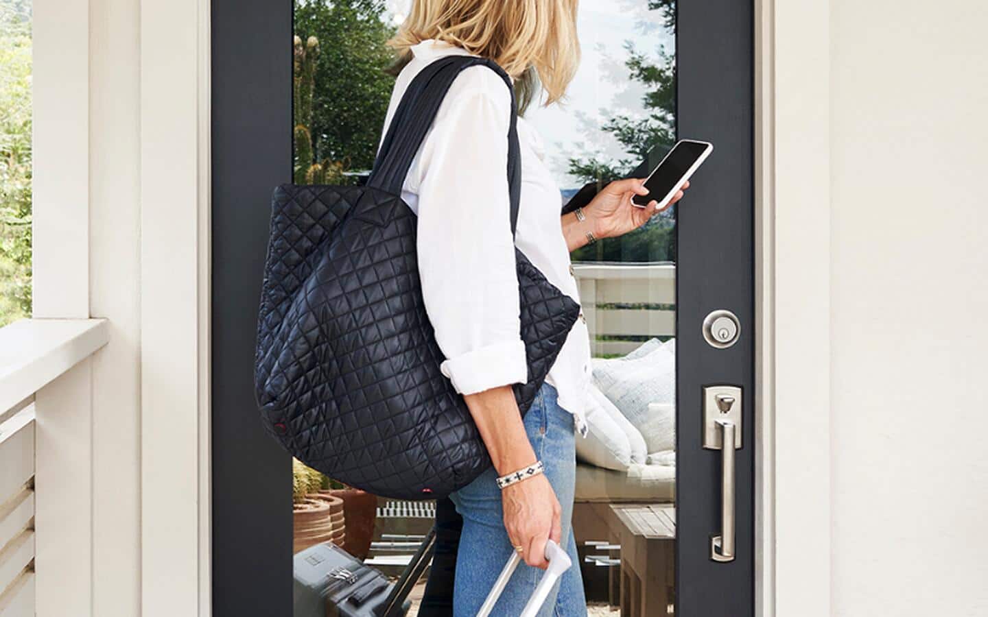 A person uses their smartphone to alert a smart doorbell. A person uses their smartphone to alert a smart doorbell.