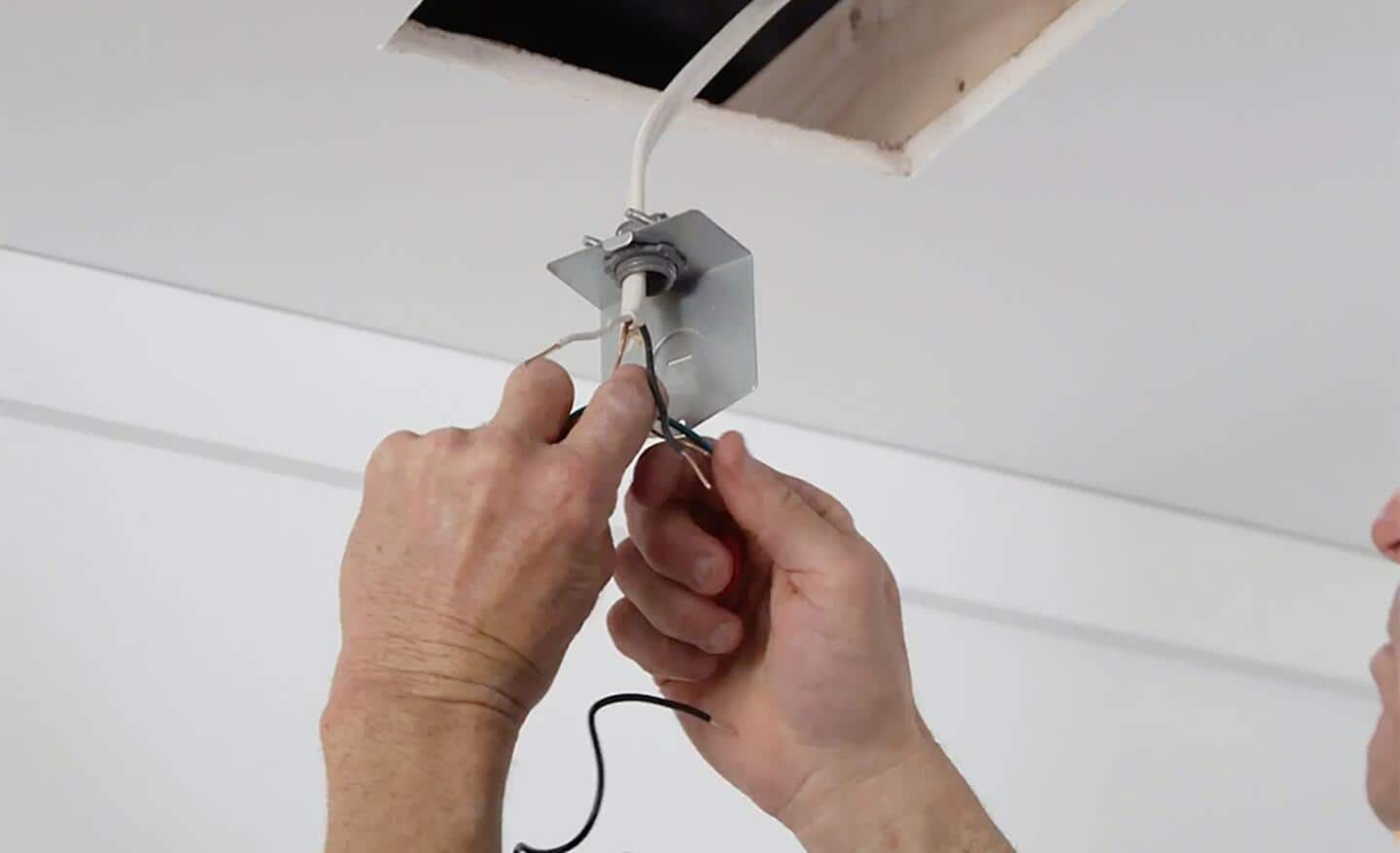 Person wires the switch for ceiling fan