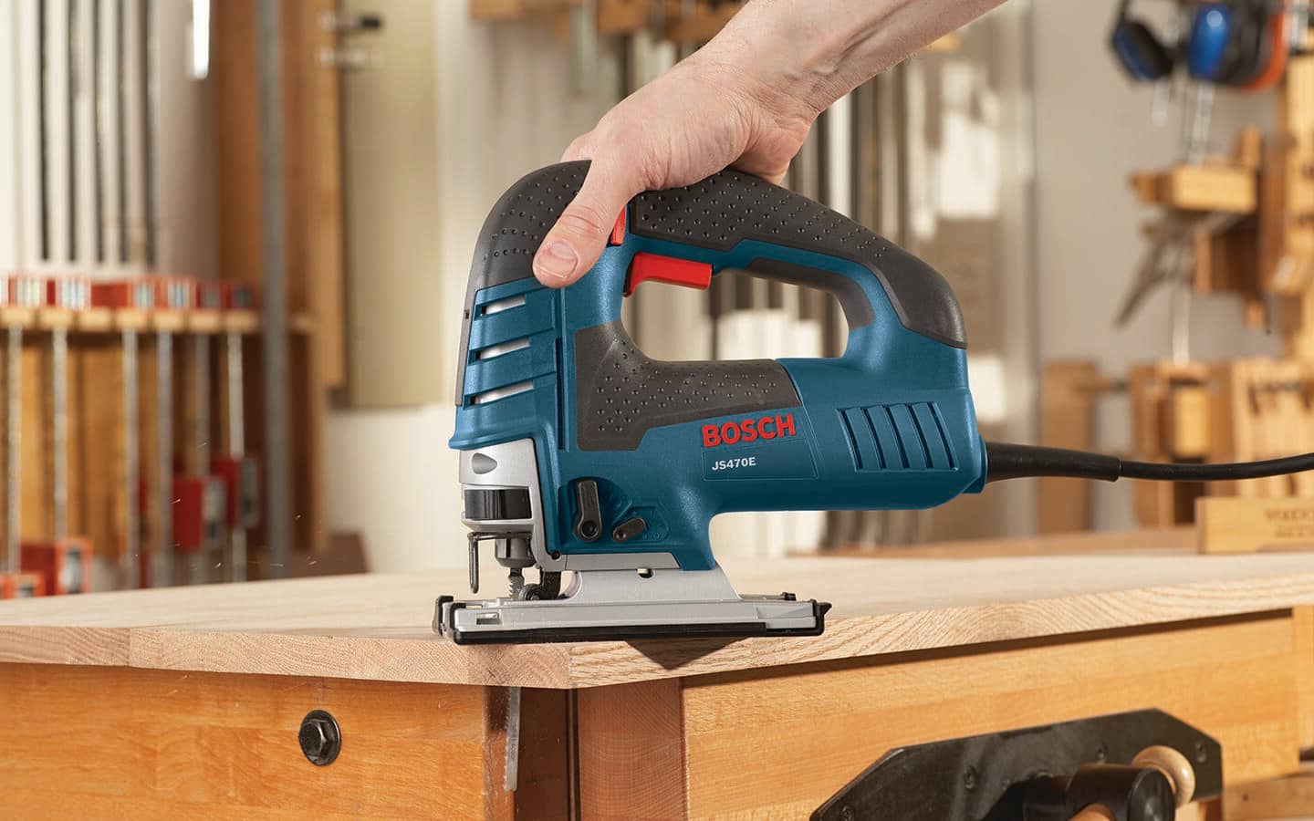 A corded jigsaw in a woodshop. A corded jigsaw in a woodshop.