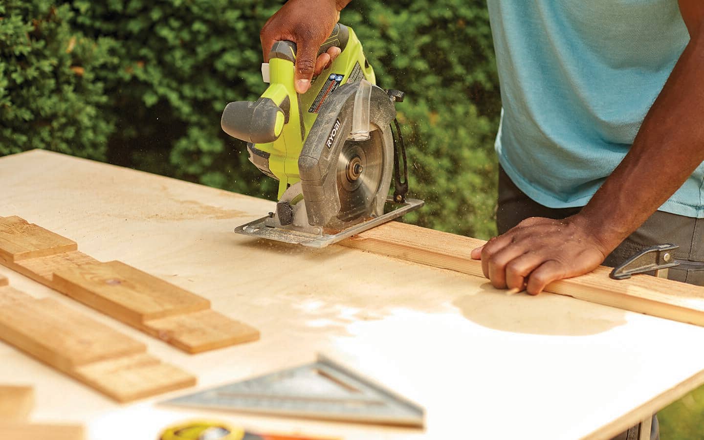 Someone cutting boards for a cold frame top.