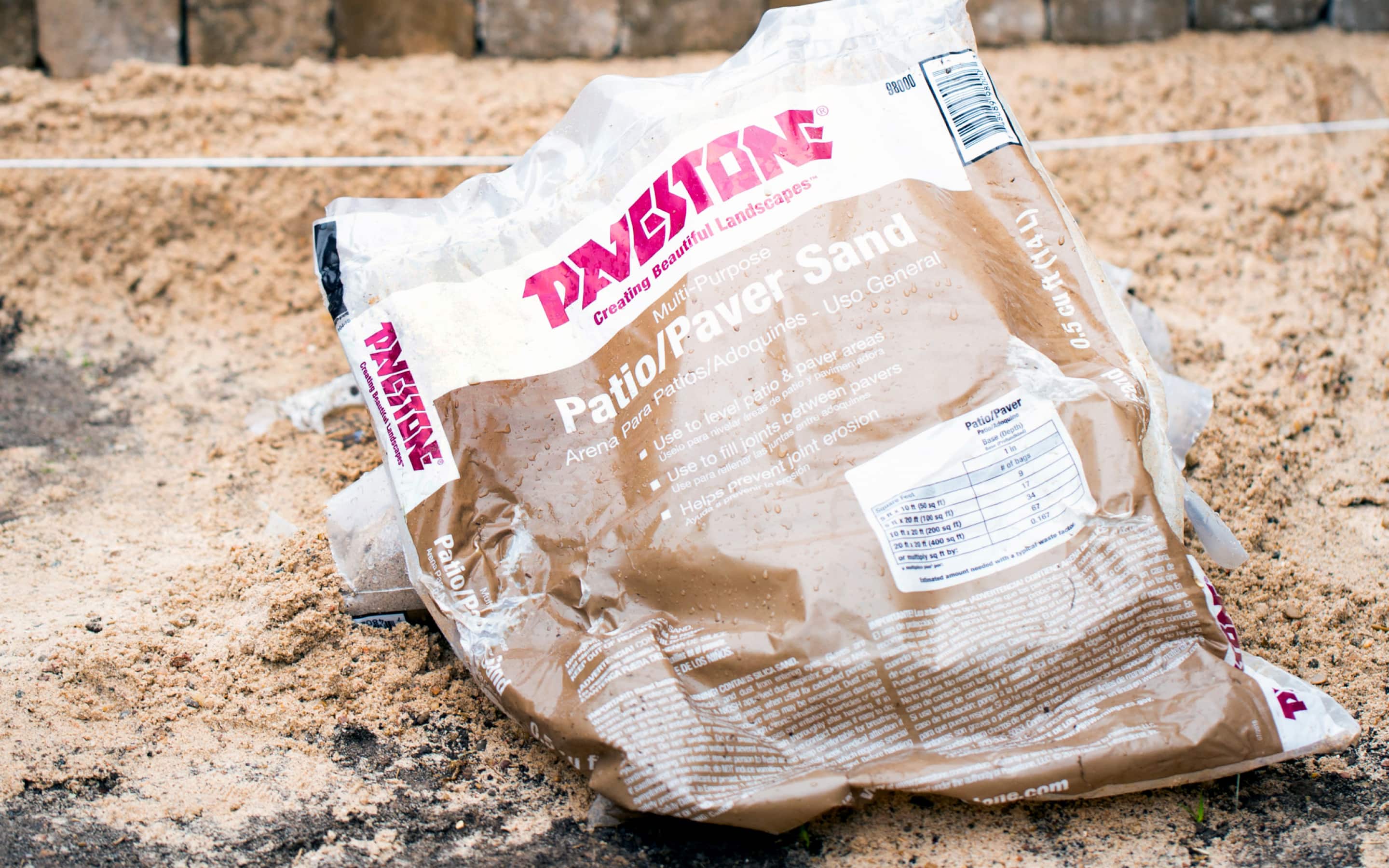 A bag of paver sand on the ground.