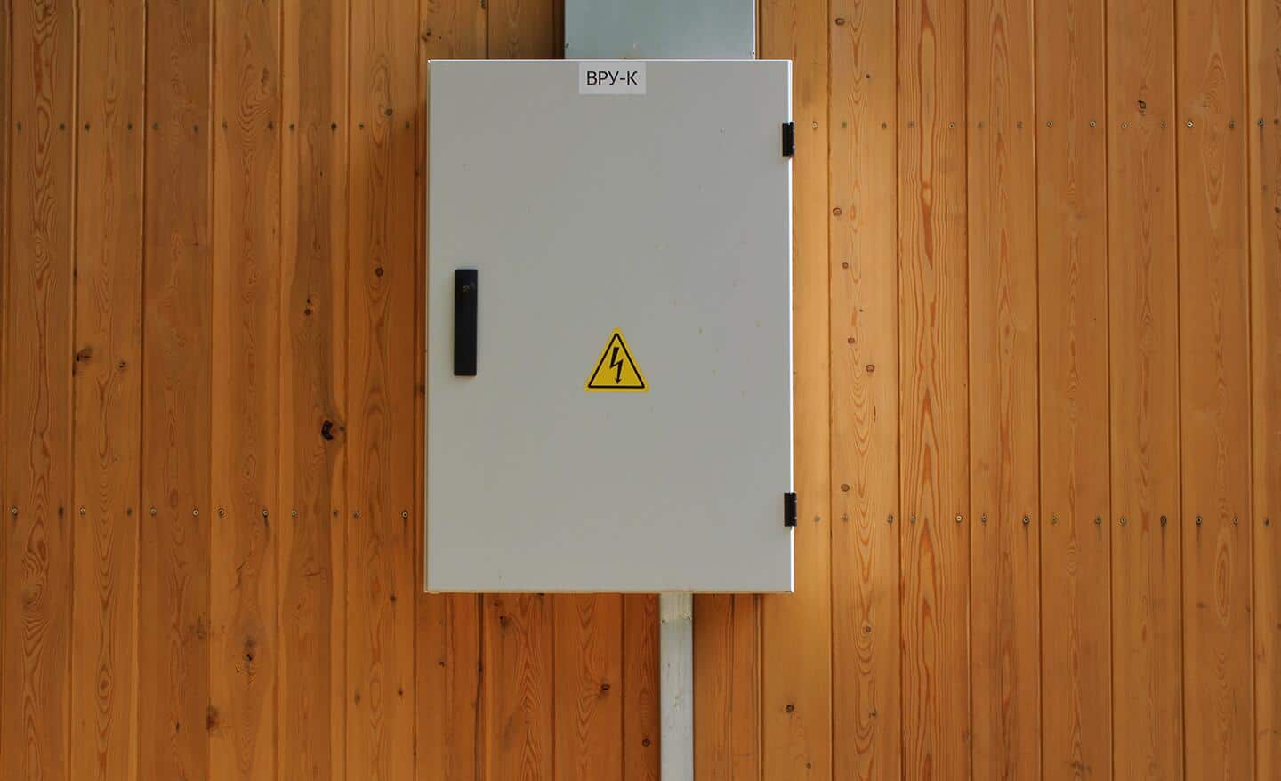 A closed electrical panel on a wall.