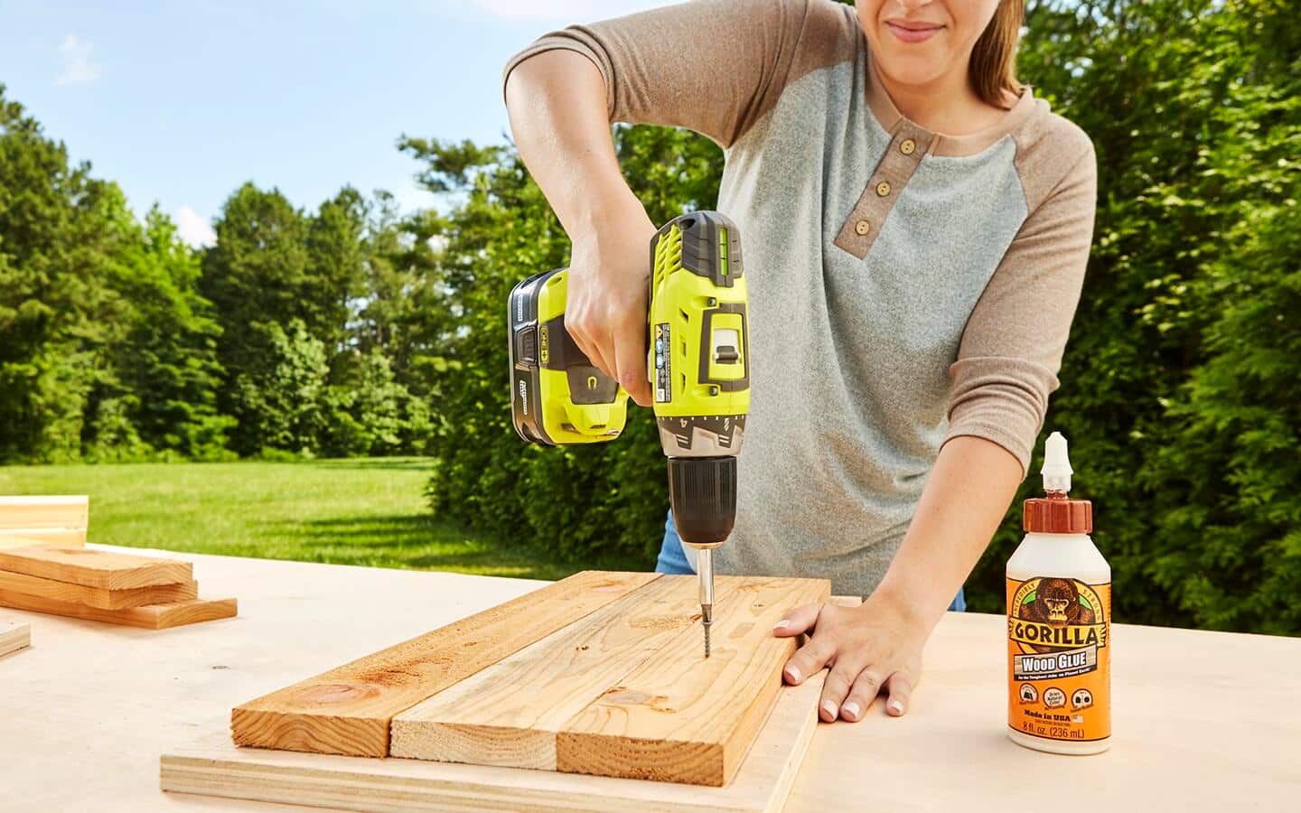 A person uses a power drill to attach boards to a root cellar floor. A person uses a power drill to attach boards to a root cellar floor.