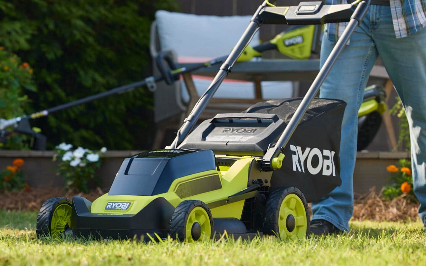 An individual uses a light-green, high-wheel push mower. An individual uses a light-green, high-wheel push mower.