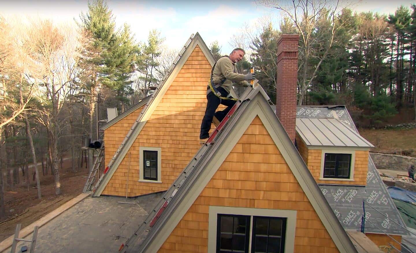 A person on top of a roof installing roofing.