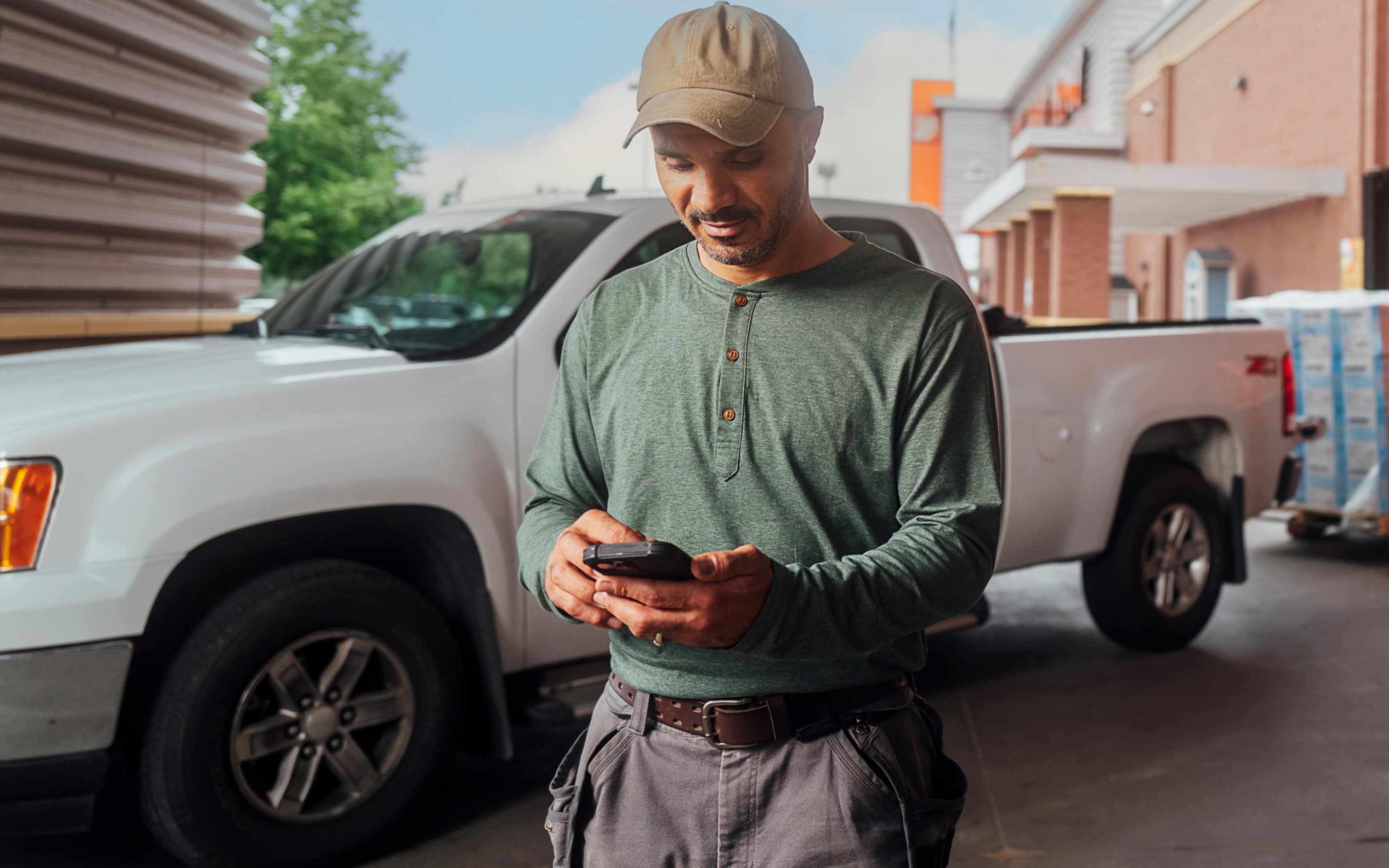 A Pro holding his cell phone in front of a truck.