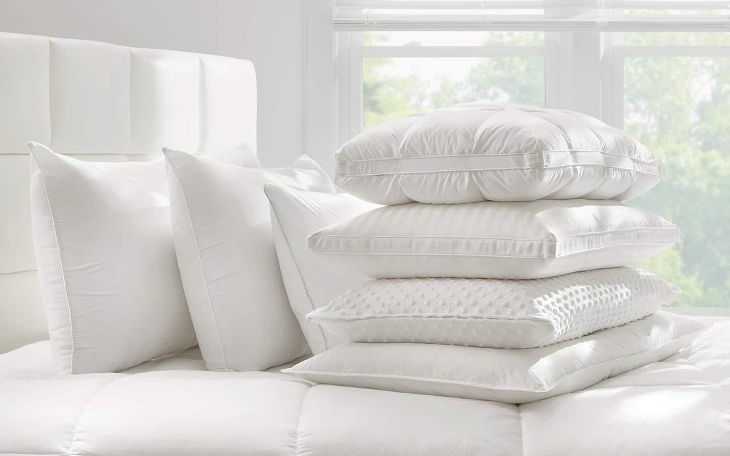 A variety of pillows on a bed. A variety of pillows on a bed.