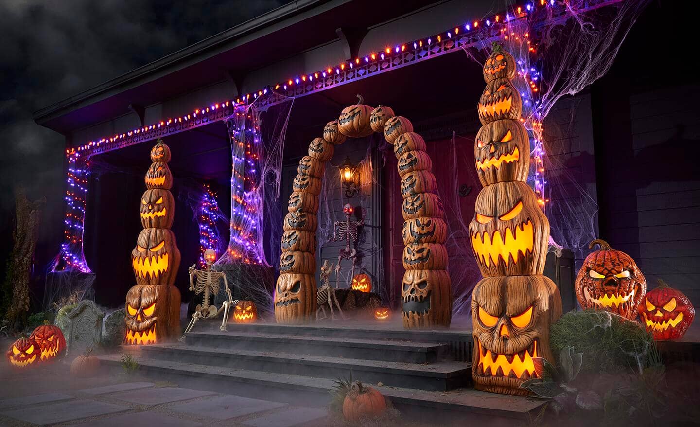 Strings of lights in orange and purple plus other lighted decor cover a house for Halloween.