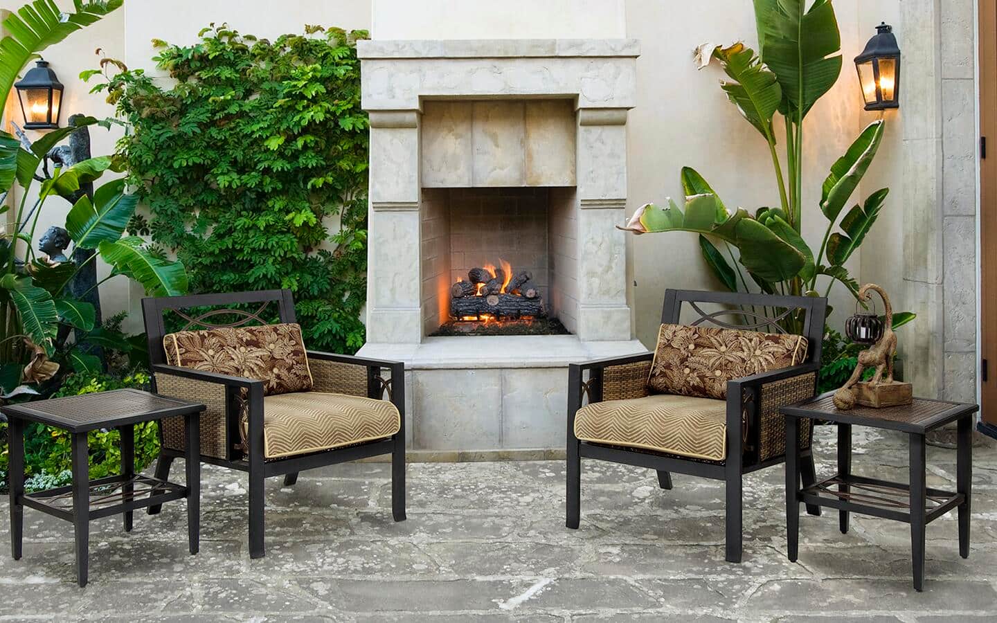 An outdoor fireplace made of light-colored stone on a patio.