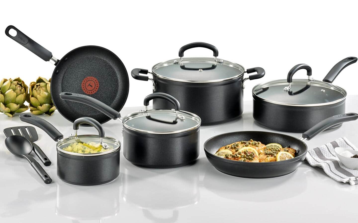 A full set of titanium cookware containing food.