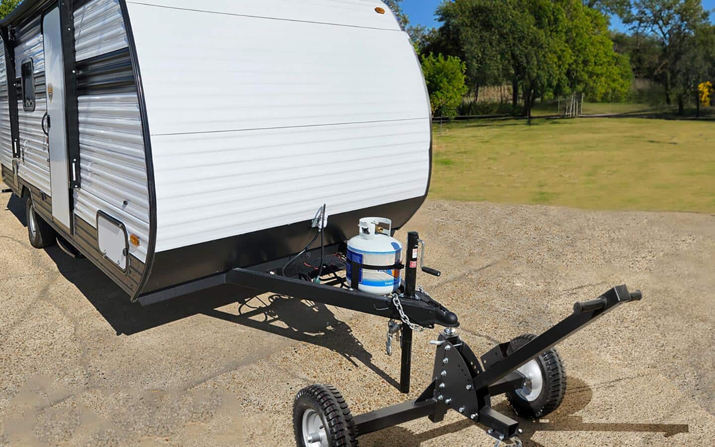 A black trailer hitch connected to a white RV.